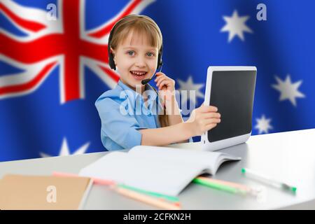 Australia concept with little girl student with book on the Australian flag background Stock Photo