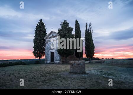 Chapel Cappella della Madonna di Vitaleta in Val d' Orcia, Tuscany, Italy at Sunrise or Dawn in the Romantic and Mysterious First Light Stock Photo