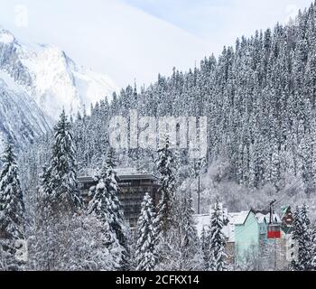 Dombay, Karachay-Cherkess Republic, Russia-December 15, 2018: Red cableway down the mountain to the village. Top view of hotel Mountain Top in St. Kar Stock Photo