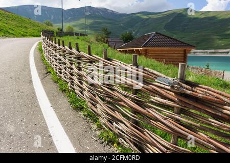 Vedensky district, Chechen Republic, Russia - June 01, 2019: The original fence along the road of woven long branches. Ethnic decoration Stock Photo