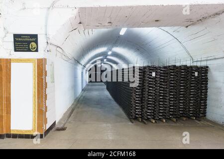 Novy Svet, Crimea, Russia - March 09, 2019: Stacks with bottles of champagne factory 'Novy Svet'. Sign in Russian 'Tunnel anniversary in honor of the Stock Photo