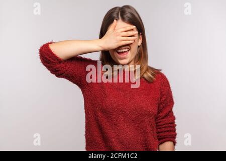 Don't want to look! Portrait of girl in shaggy sweater keeping hand on eyes and grimacing in disgust, avoiding watch at something shameful, gross. ind Stock Photo