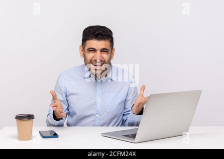 What do you want? Annoyed businessman, angry boss sitting in office, raising hands indignant irritated looking at camera, misunderstanding at work. in Stock Photo