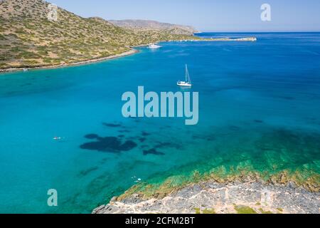 Sailing boats and yachts in the crystal clear waters of the Aegean Sea (Crete, Greece) Stock Photo