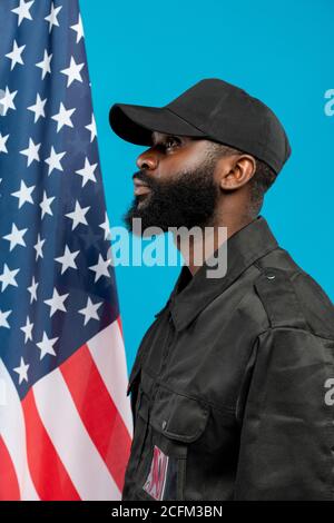 Side view of young bearded African-american male security in black uniform Stock Photo