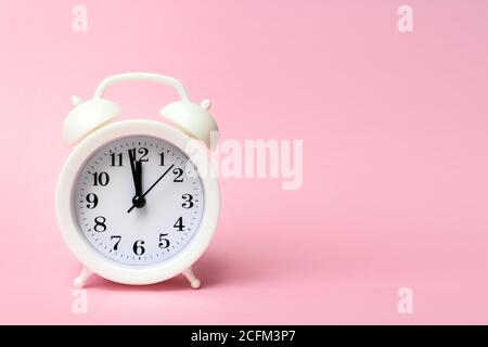 White alarm clock on colorful background. Trendy minimal style. Beauty and fashion concept. Flat lay composition. Top view Stock Photo
