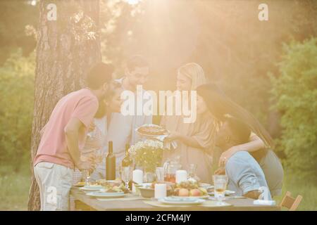 Circle of cheerful young intercultural friends gathered under tree having fun Stock Photo