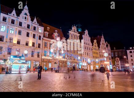 Wroclaw, Poland - 25.11.2019: Festive Market of Rynek Square against Historic old town hall building. Long lasting exposure. Stock Photo