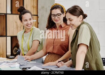 Contemporary young female fashion designers choosing textile for one of items Stock Photo