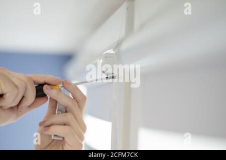 Man installing cassette roller blinds on windows Stock Photo