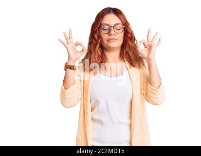 Young latin woman wearing business clothes relax and smiling with eyes closed doing meditation gesture with fingers. yoga concept. Stock Photo