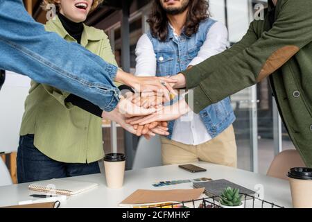 Happy young creative designers or software developers making pile of hands Stock Photo