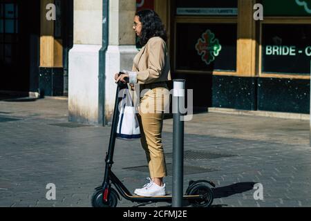 Reims France September 04, 2020 View of unidentified people rolling with an electric scooter in the streets of Reims, operating with a small utility i Stock Photo