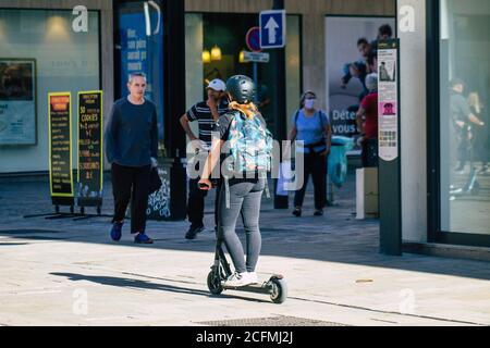 Reims France September 04, 2020 View of unidentified people rolling with an electric scooter in the streets of Reims, operating with a small utility i Stock Photo