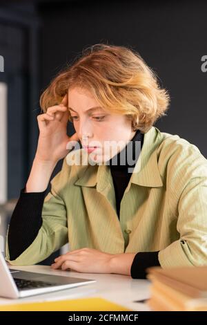 Young serious female developer of software looking through online information Stock Photo