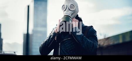 young man wearing a gas mask on a city street Stock Photo