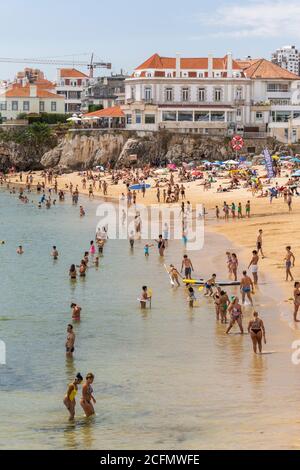 Beach full of locals and tourists on a sunny summer weekend in Cascais ...