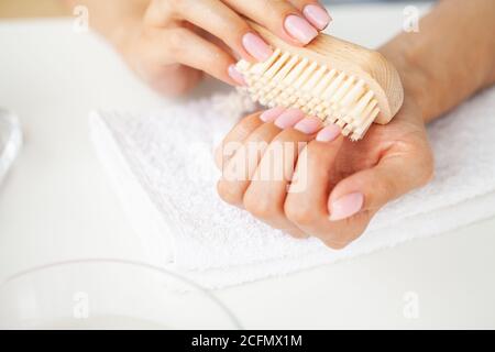 Close up of woman using nail brush on fingernails Stock Photo