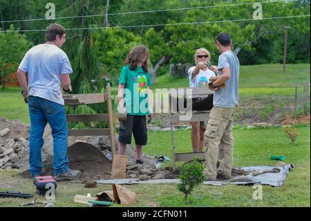 HAZLETON, PA - JUNE 30:  From left, Adam Yeager, Jonathan Nick, a student and  Mike Roller work at the site of an archaeologic dig as a neighbor watch Stock Photo