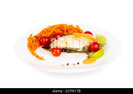 Fried cooked catfish steak with garnish of sauce and vegetables on white plate isolated on white background Stock Photo