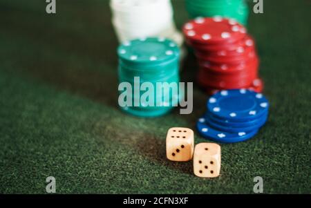 Casino poker chips stack dice on green felt background Stock Photo
