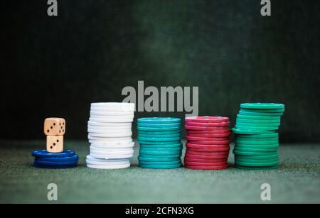 Casino poker chips stack dice on green felt background Stock Photo