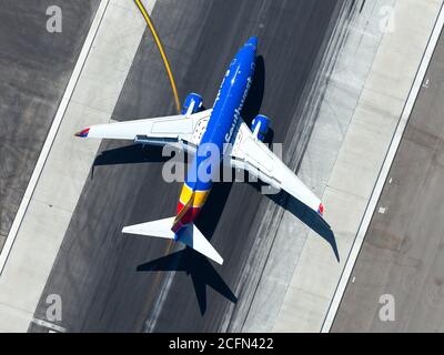 Southwest Airlines Boeing 737 arriving at Los Angeles Airport. Aerial view of airplnae over runway after landing. Wing flaps and slats visible. Stock Photo