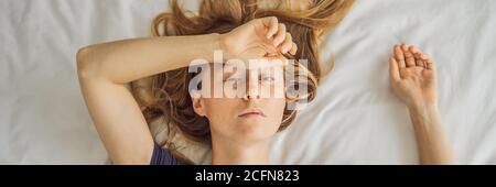 BANNER, LONG FORMAT Extremly tired young woman lying on the bed, home alone. self-isolation at home, quarantine due to pandemic COVID 19. Mental Stock Photo