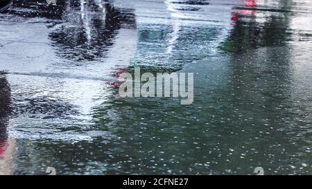 heavy rain in the city. raindrops and water circles on flooded road during downpour Stock Photo