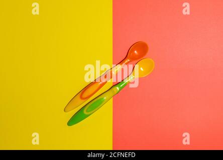 Flat lay of bright multi-colored spoons on a two-colored background. Stock Photo