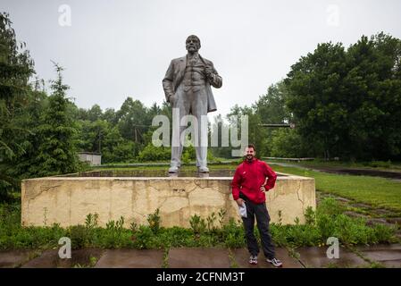 Pripyat / Ukraine - May 15, 2018: Young Western tourist in front of Lenin Monument at the entrance of Pripyat Stock Photo