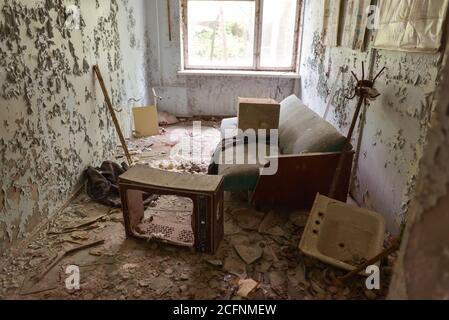 Pripyat / Ukraine - May 15, 2018: sofa and television in destroyed living room in abandoned Pripyat, Ukraine Stock Photo