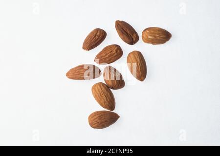 A handful of almonds scattered on a white background. Stock Photo