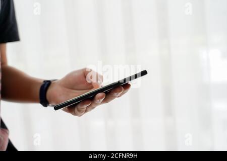 Close up of man's hand holding smartphone, using device to connect online, business person working remotely with mobile phone Stock Photo