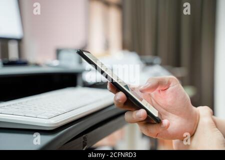 Close up of man's hand holding mobile phone, touchscreen technology, with sore wrist, repetitive strain, text claw Stock Photo