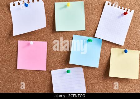 Sticky notes pinned on cork board. Planning and brainstorming concept Stock Photo