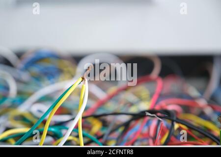 Disorganized colorful stripped cables on a drawer. Messy wires. Stock Photo