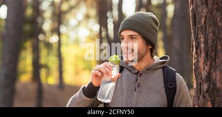 Closeup of young man drinking water in forest Stock Photo