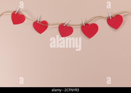 View of a heart necklace held by clamps on pink background Stock Photo