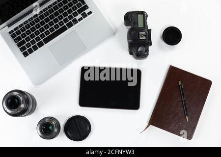 View of school supplies with a laptop and a tablet with a camera and lance in a white background Stock Photo