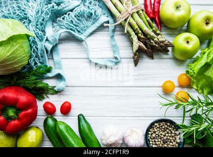 Fresh vegetables and fruits with a string bag on a white wooden background. Healthy lifestyle. Top view. Zero waste. Stock Photo