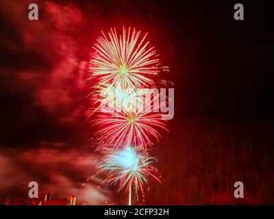 Bright flash of fireworks in red shades. Photo with filter Stock Photo