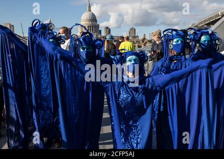 London, UK. 6th September, 2020. The blue rebels cross the Millennium Bridge with fellow climate activists from the Ocean Rebellion and Extinction Rebellion during a colourful Marine Extinction March. The activists, who are attending a series of September Rebellion protests around the UK, are demanding environmental protections for the oceans and calling for an end to global governmental inaction to save the seas. Credit: Mark Kerrison/Alamy Live News