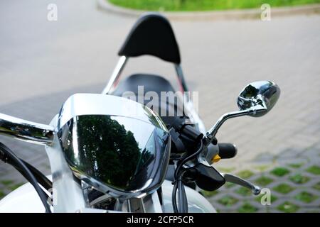 Closeup of a classic motorcycle handlbar and chrome headlight and mirror. Stock Photo