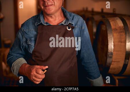 Unrecognized male sommelier in apron and denim shirt Stock Photo