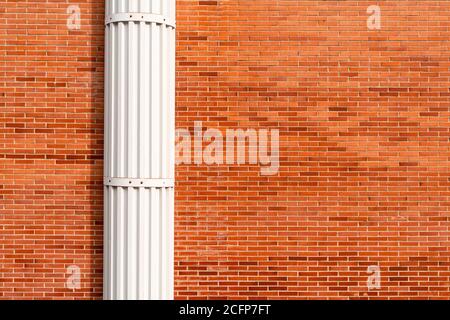 Red brick wall with white decorative column. Copspace Stock Photo