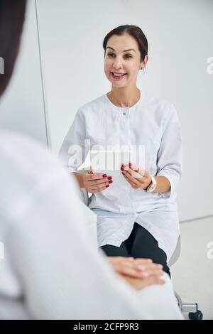 Smiling cosmetologist consulting her client in a beauty parlor Stock Photo