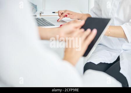 Two Caucasian women using their gadgets indoors Stock Photo