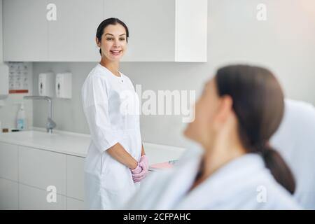 Cheerful middle-aged beautician looking at her client Stock Photo