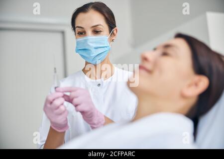 Dermatologist checking for air bubbles in the syringe Stock Photo